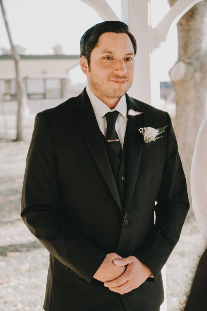 A man in a suit and tie standing outside.