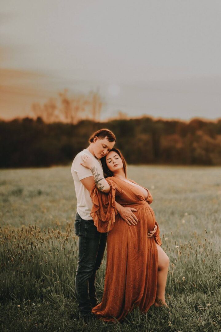 A man and woman hugging in the middle of a field.