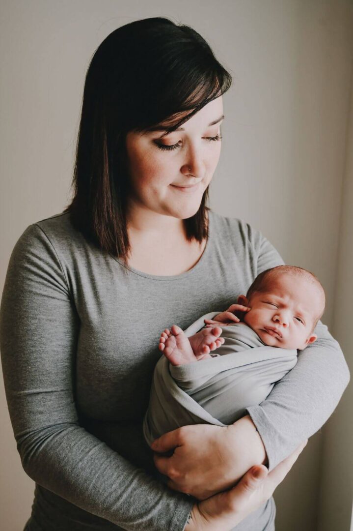 A woman holding a baby in her arms.