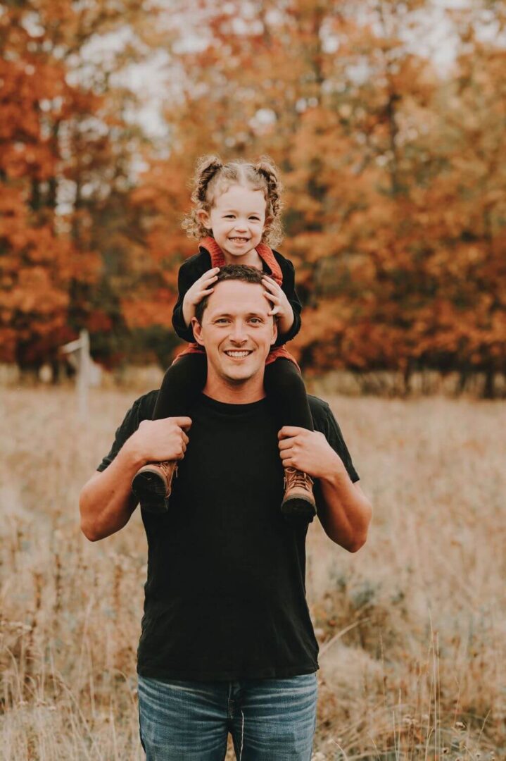 A man holding his daughter on top of him.