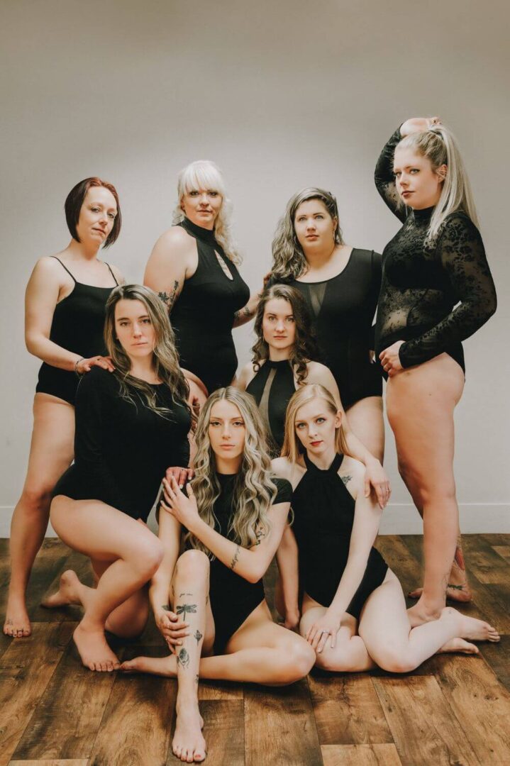 A group of women in black outfits posing for the camera.