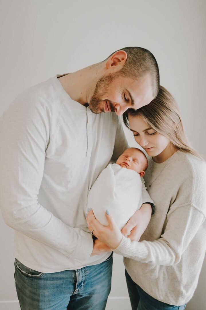 A man and woman holding a baby in their arms.