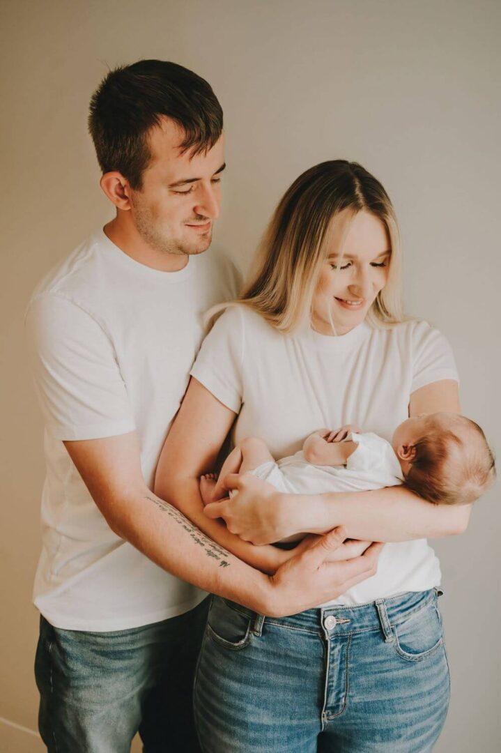 A man and woman holding a baby in their arms.