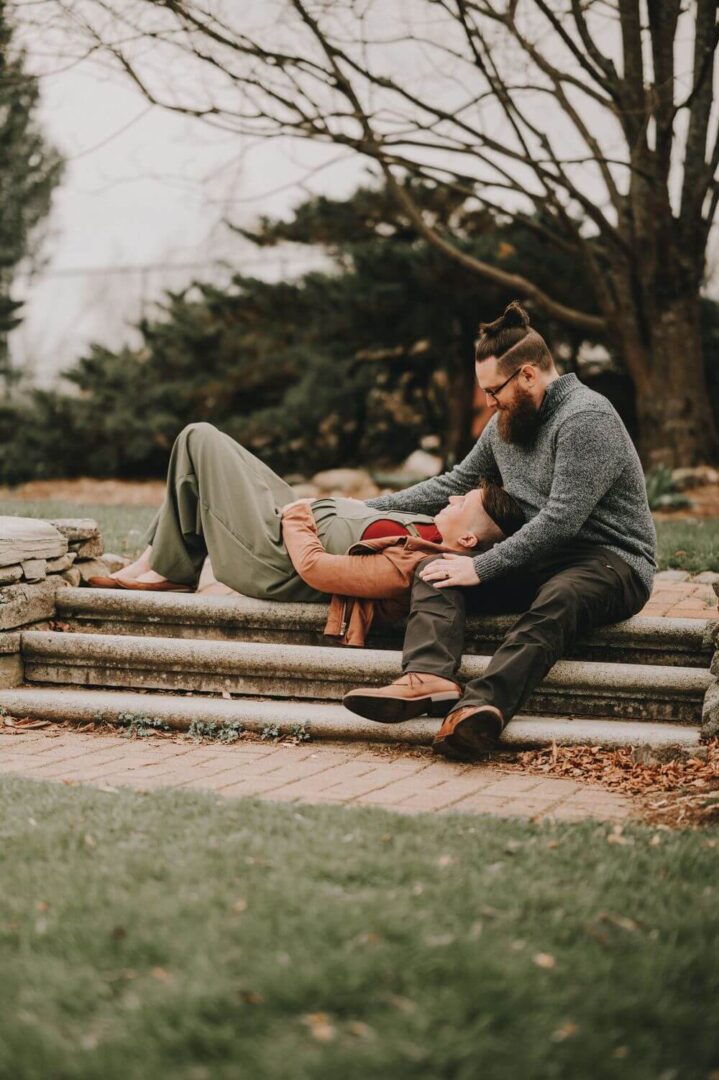 A man sitting on the ground next to another person.