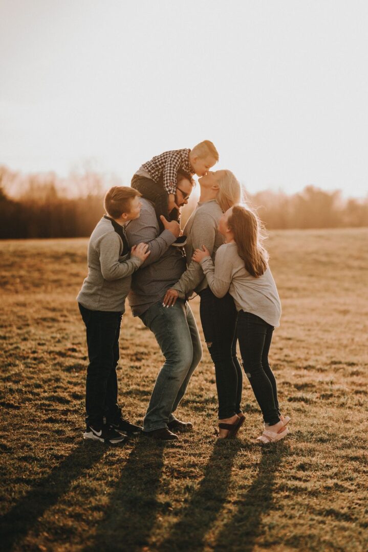 A group of people standing in the grass.