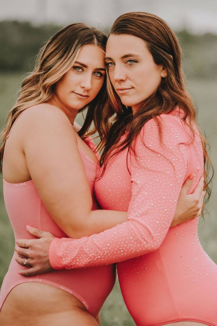 Two women in pink hugging each other.