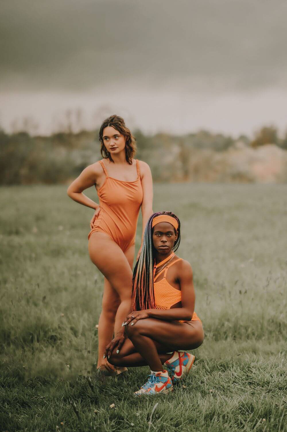 Two women in orange bathing suits pose for a picture.